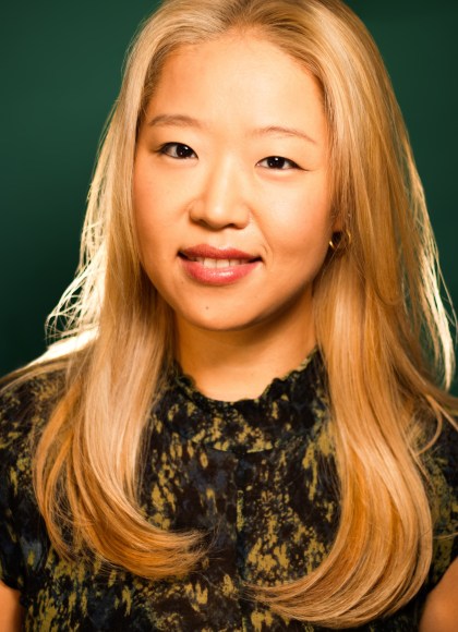 Photo of author Grace Jung. The photo is taken from a slight angle and Grace looks at the camera with a small smile.