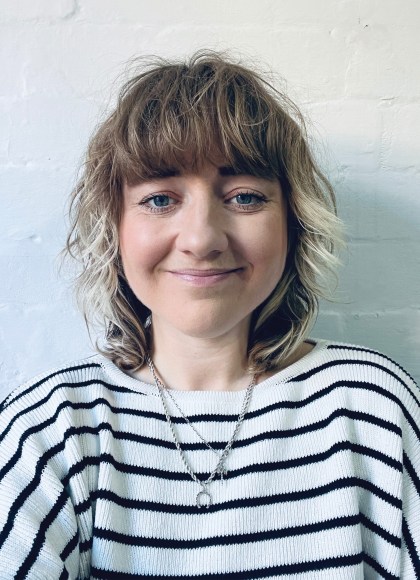 Lucy Kirk smiling and wearing a striped shirt